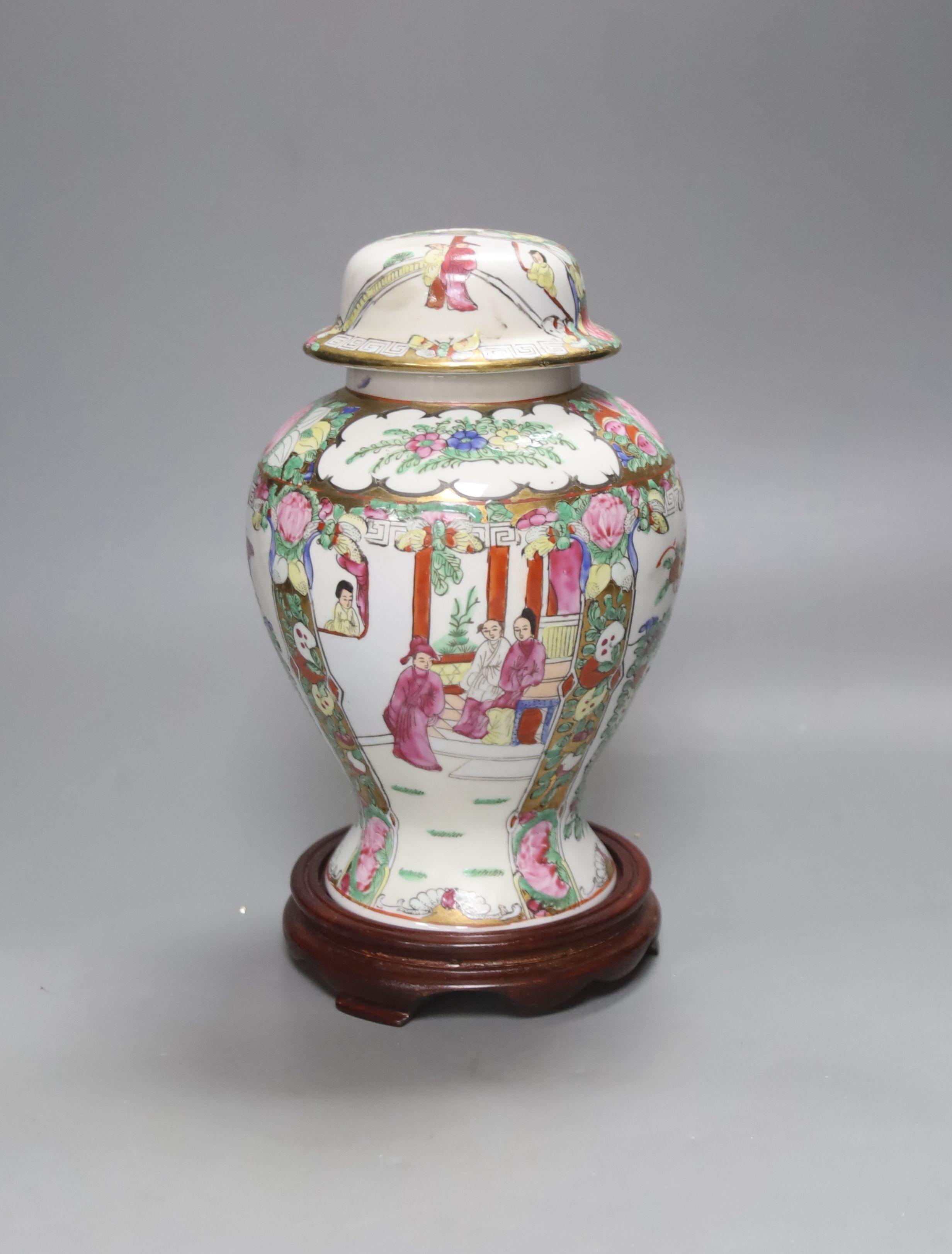 A Chinese famille rose urn shaped vase and lid, on wood plinth, 25cm